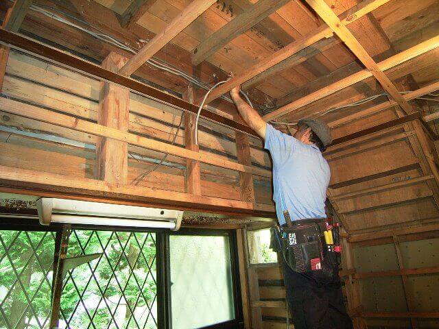解体した天井の配線を整理する作業