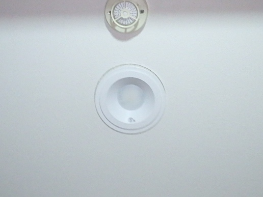ダウンライトホールカバーの縁（11.5mm）から、クロスの貼られていない隙間がはみ出して露出している状態