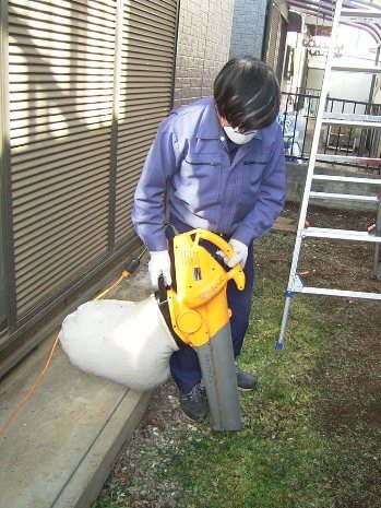雑草をバキュームで吸い込む作業