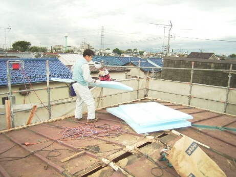 屋根に断熱材を運ぶ