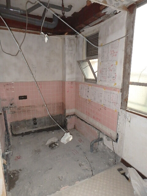 間仕切り壁と床とタイル壁の一部を撤去した浴室
