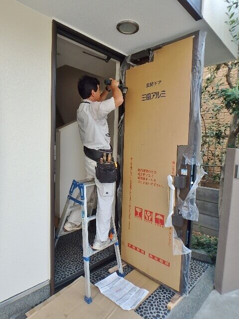 新規玄関ドアの丁番を固定する