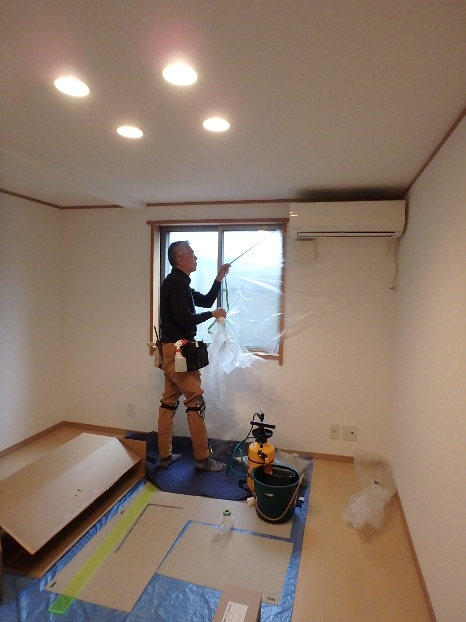 施工完了後、窓まわりを美しく清掃し、窓回りのマスカーなどの防水養生を慎重に撤去する様子